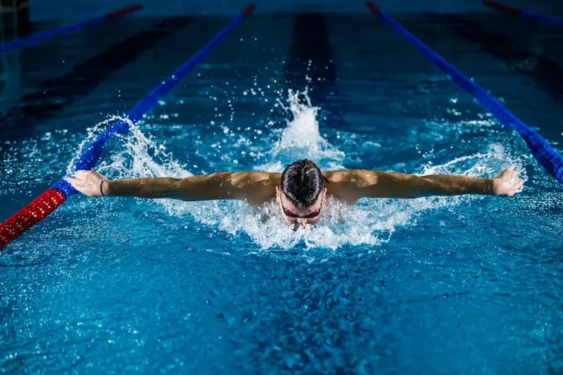 Athlete performing butterfly stroke in an indoor swimming pool during training