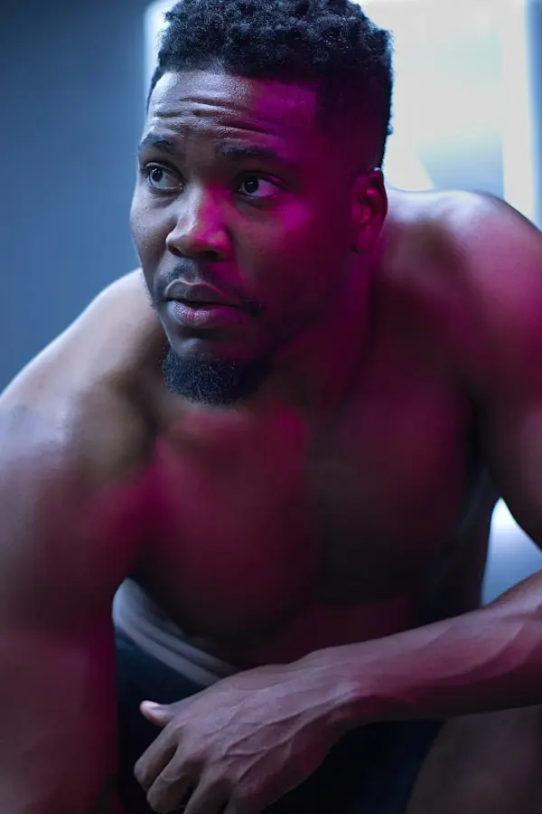Close-up of a person resting during an intense gym workout under dramatic lighting